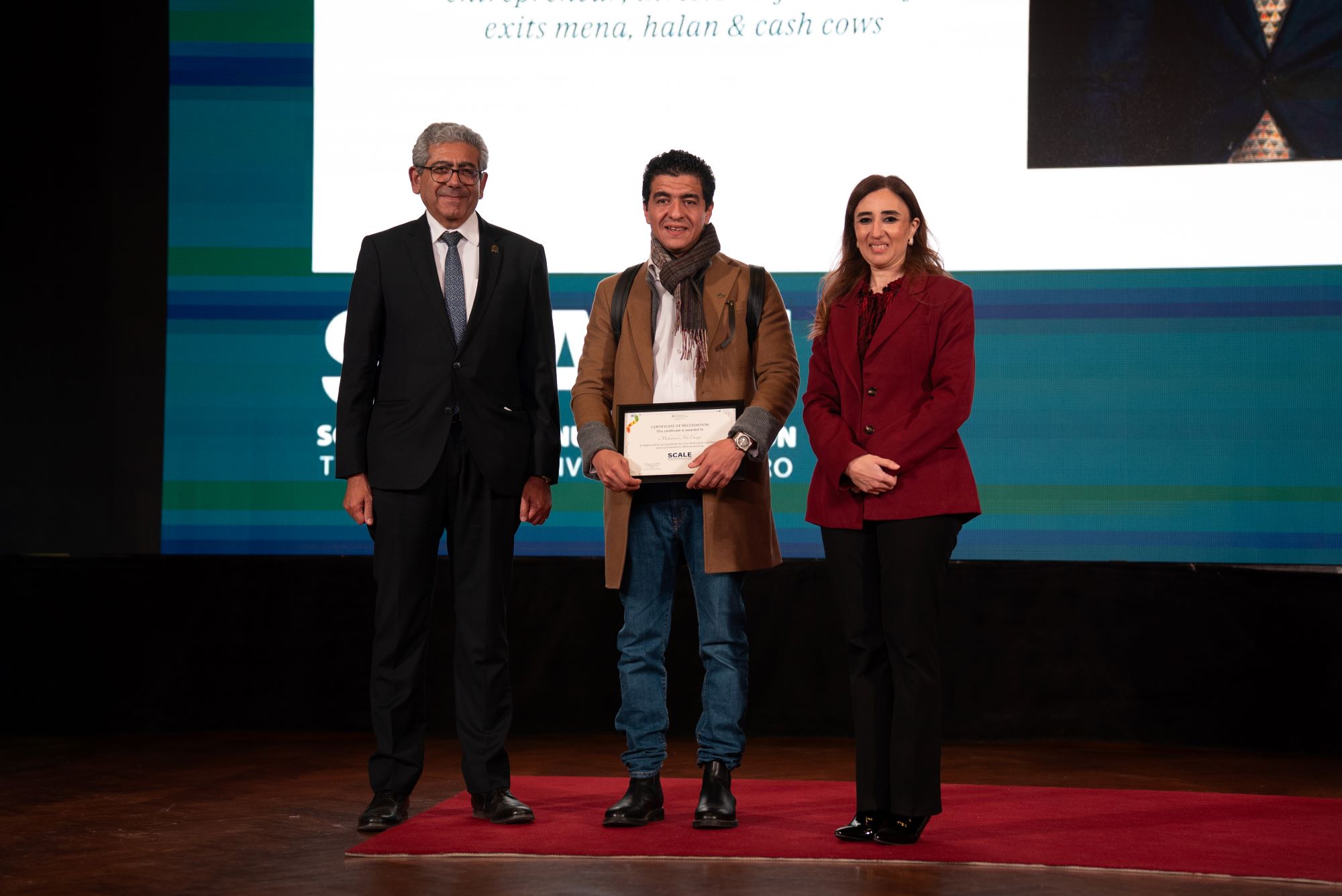 Mr. Mohamed Abo el Naga receiving his SCALE pin on Ewart Hall stage. beside hin Dr. Mahmoud Allam, SCE Dean and Dr. Doaa Salem