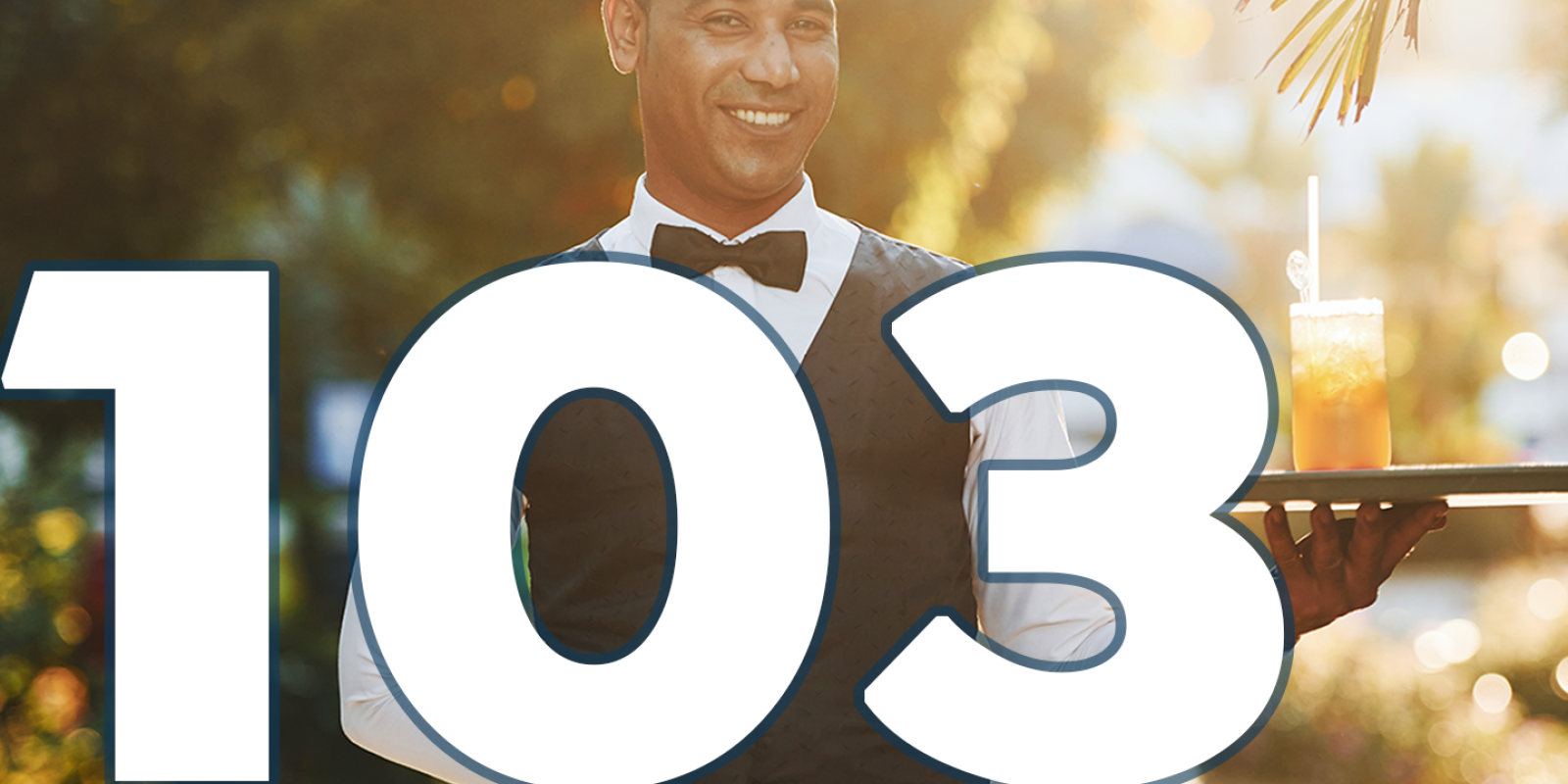 A waiter is holding a tray. There is a glass of juice on it. Text 103