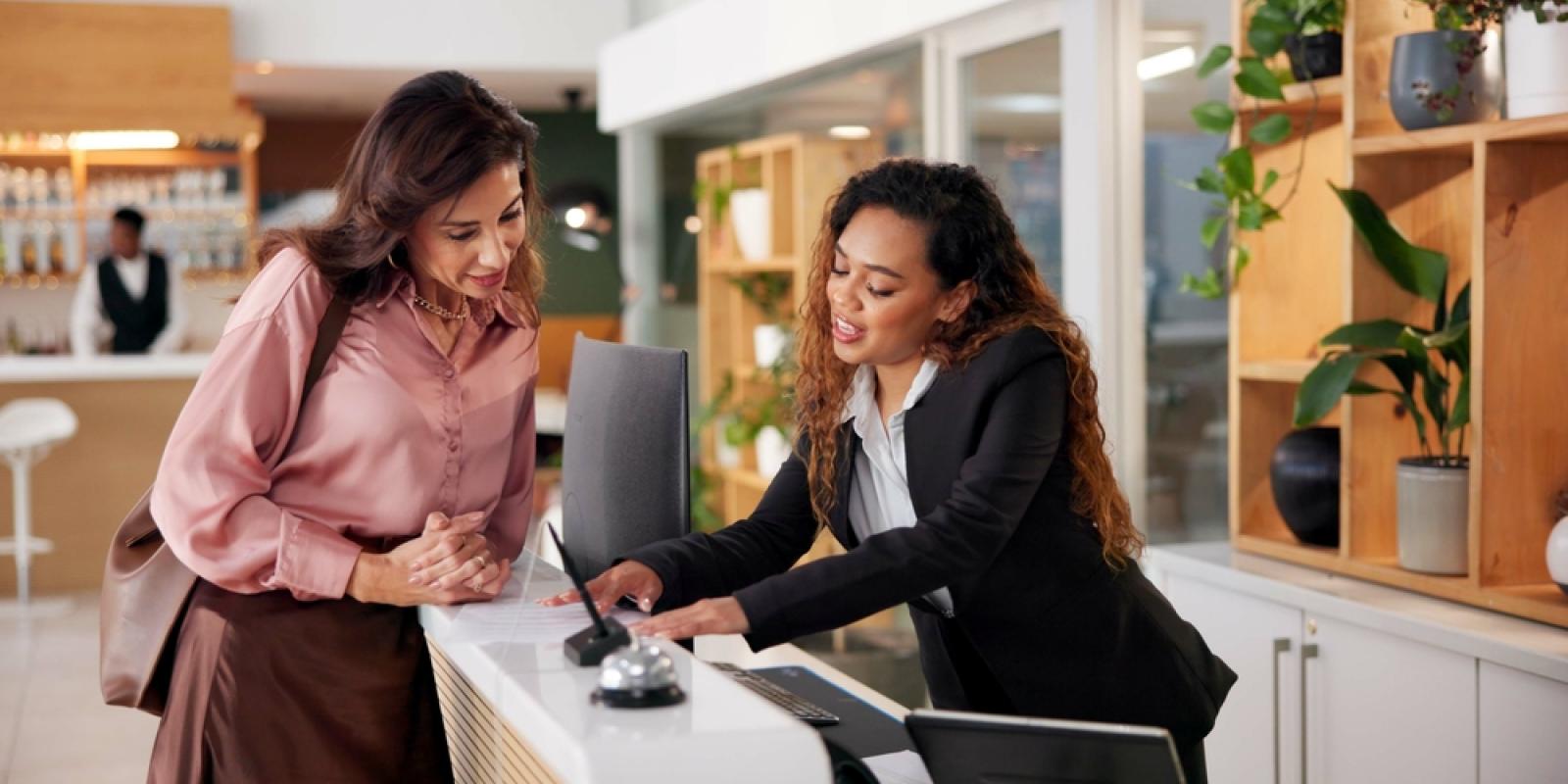 Hotel, receptionist and woman with paperwork for booking, guest room service