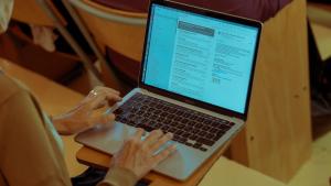 student is following up in class on her laptop