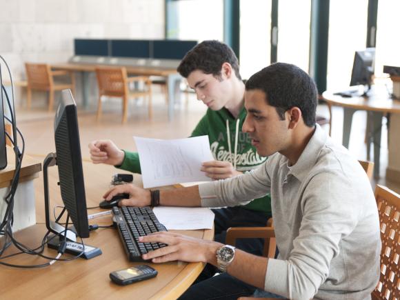 students working on computers in AUC library