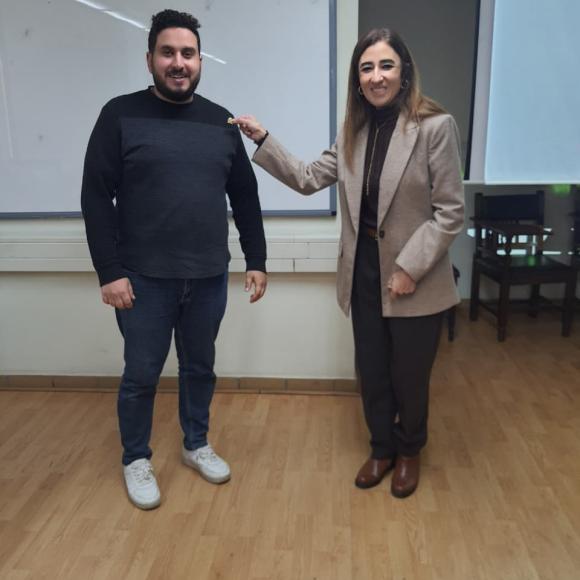 Dr. Doaa Salem is giving a SCALE pin to one of the students 